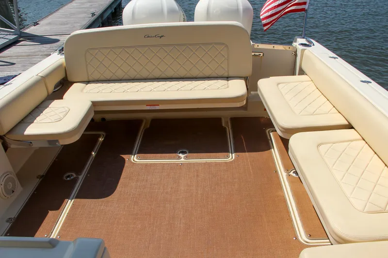 Slide: The Image of 2017 Chris-Craft Calypso 30 boat interior with beige seating and American flag. - 19