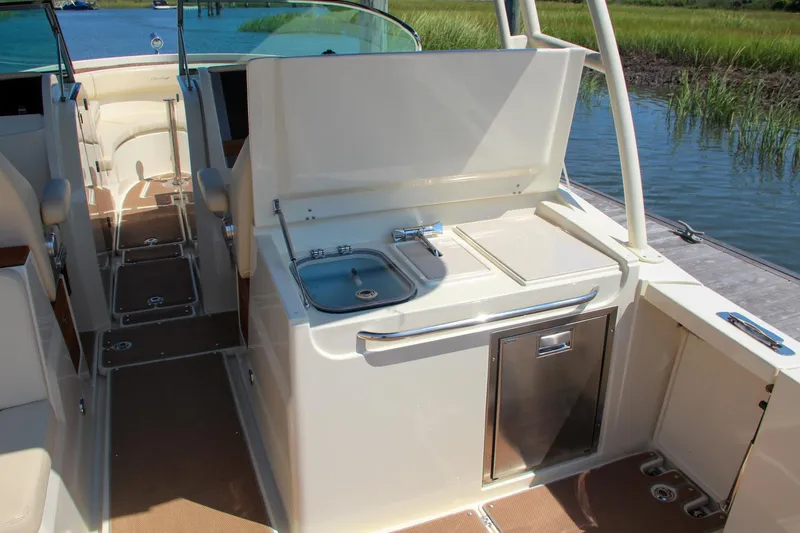Slide: The Image of 2017 Chris-Craft Calypso 30 boat interior with kitchenette and seating area. - 27