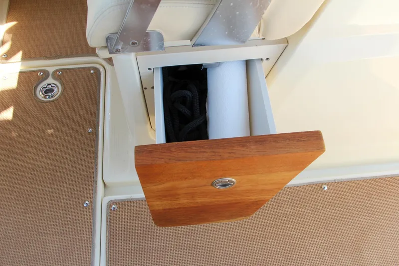 Slide: The Image of 2017 Chris-Craft Calypso 30 boat storage compartment with wooden lid. - 37