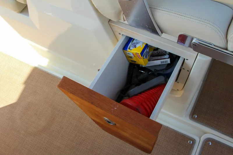 Slide: The Image of Open storage drawer on 2017 Chris-Craft Calypso 30 boat, containing various items. - 38