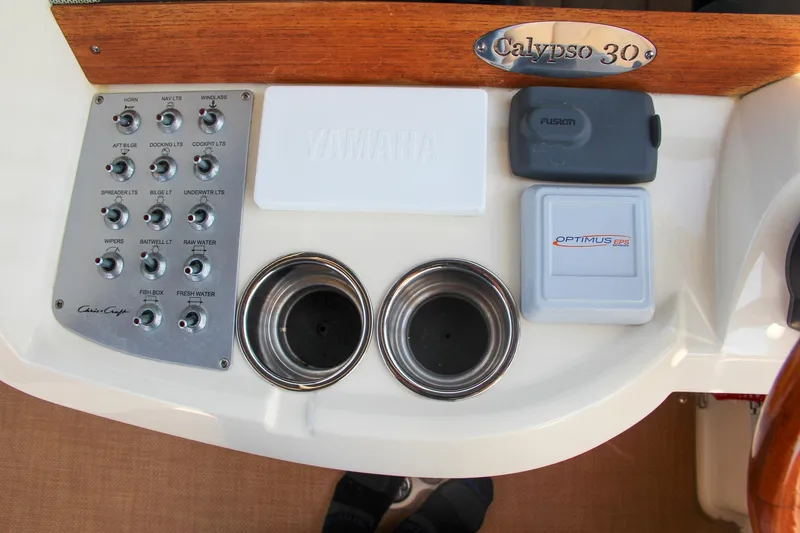 Slide: The Image of Control panel of 2017 Chris-Craft Calypso 30 boat with cup holders and switches. - 48