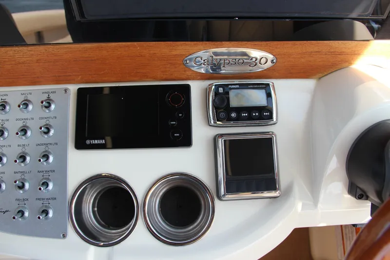 Slide: The Image of Dashboard of 2017 Chris-Craft Calypso 30 with controls and cup holders. - 49