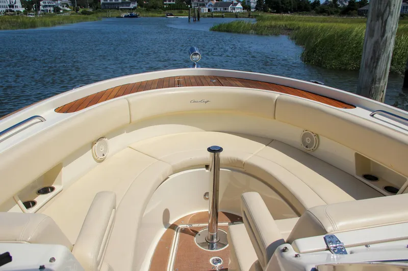 Slide: The Image of 2017 Chris-Craft Calypso 30 boat interior with elegant seating and wood accents on a calm waterway. - 6