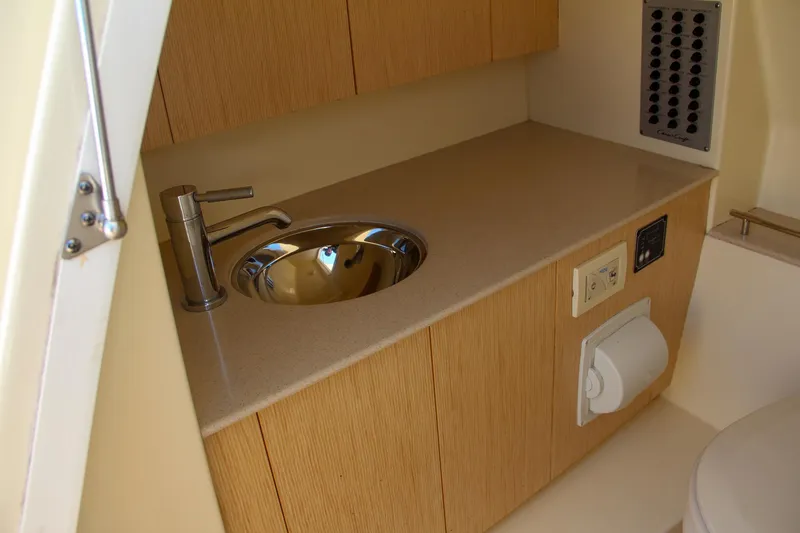 Slide: The Image of 2017 Chris-Craft Calypso 30 bathroom with modern sink and wooden cabinetry. - 9