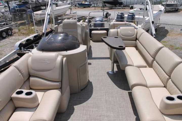 Slide: The Image of 2015 Bennington 2275 GCW pontoon boat with beige seating and table, docked in a marina. - 9