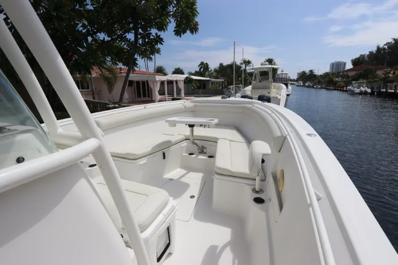 Slide: The Image of 2013 Sailfish 320 CC boat with spacious seating and table on a calm waterway. - 4