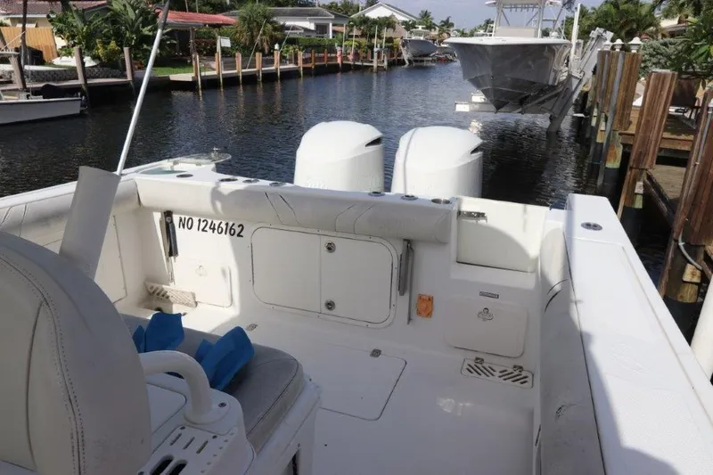 Slide: The Image of 2013 Sailfish 320 CC boat docked in a marina, rear view with twin engines. - 6