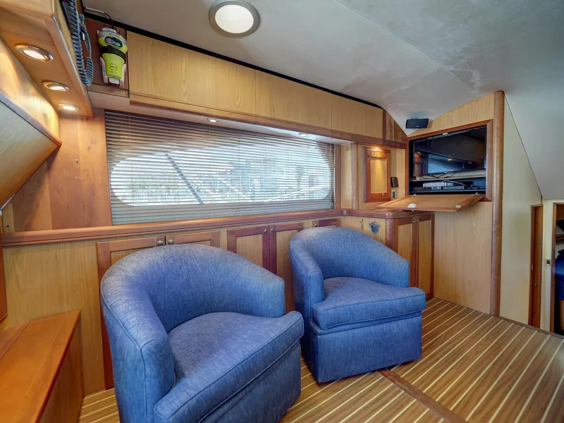 Slide: The Image of 2005 Luhrs 41 Convertible yacht interior with blue chairs and wooden cabinetry. - 10