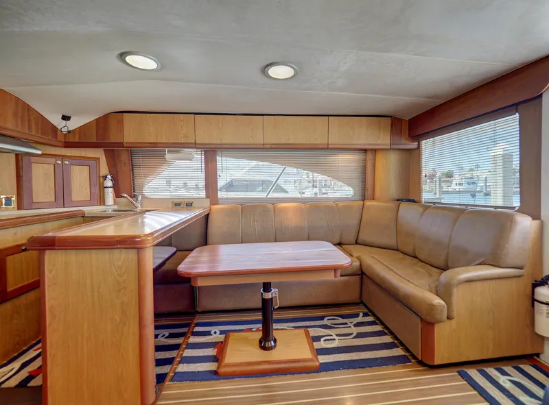 Slide: The Image of 2005 Luhrs 41 Convertible yacht interior with L-shaped sofa and dining table. - 11