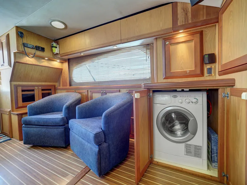 Slide: The Image of 2005 Luhrs 41 Convertible interior with blue chairs and built-in washer. - 13