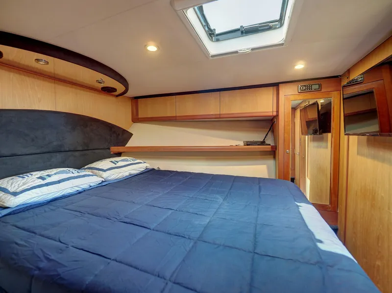 Slide: The Image of 2005 Luhrs 41 Convertible yacht bedroom with skylight and blue bedding. - 20