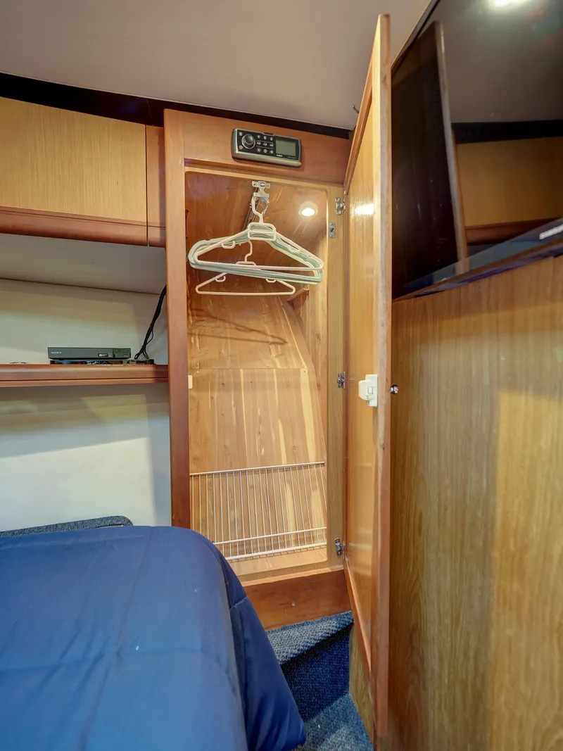 Slide: The Image of Open closet in 2005 Luhrs 41 Convertible boat cabin with hangers and shelves. - 22