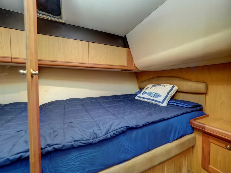 Slide: The Image of 2005 Luhrs 41 Convertible cabin with bed and storage cabinets. - 23