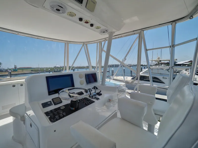 Slide: The Image of 2005 Luhrs 41 Convertible yacht helm station with dual screens and white seating. - 43
