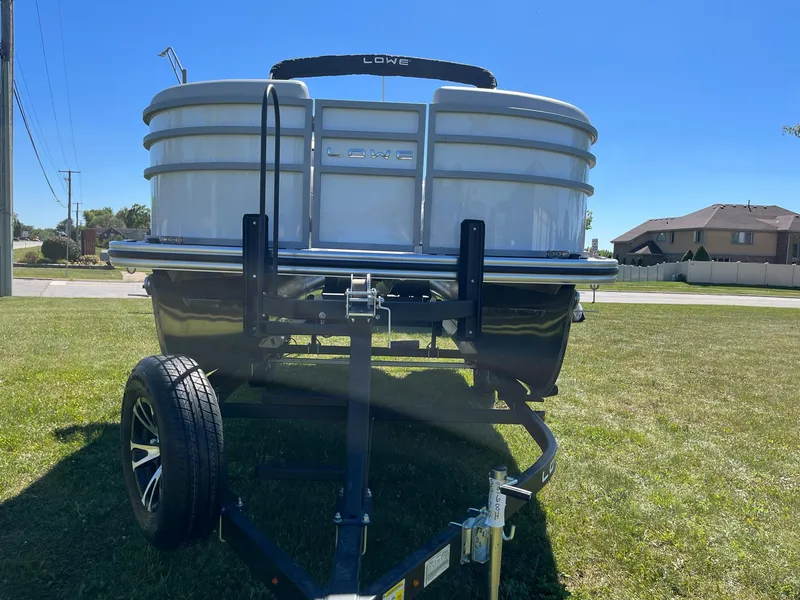 Slide: The Image of 2024 Lowe SS 170 pontoon boat on a trailer, front view. - 2