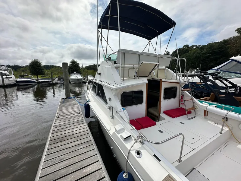Slide: The Image of 1983 Bertram 28 boat docked at marina with canopy. - 10
