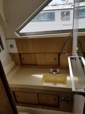 Slide: The Image of 1983 Bertram 28 boat interior with sink and wooden cabinets. - 14