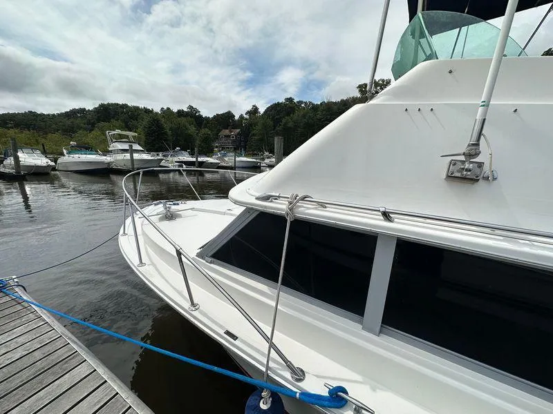 Slide: The Image of 1983 Bertram 28 boat docked at a marina with other boats in the background. - 15
