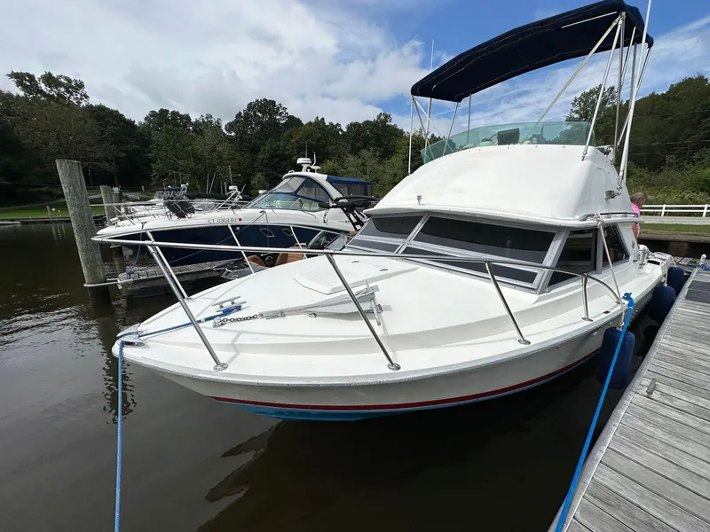 Slide: The Image of 1983 Bertram 28 boat docked at a marina. - 16