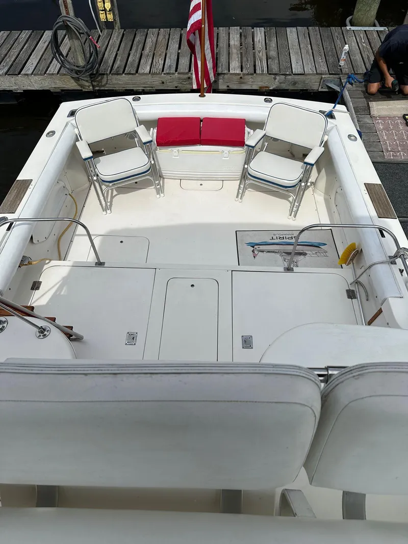 Slide: The Image of 1983 Bertram 28 boat with spacious deck, seating, and American flag. - 19