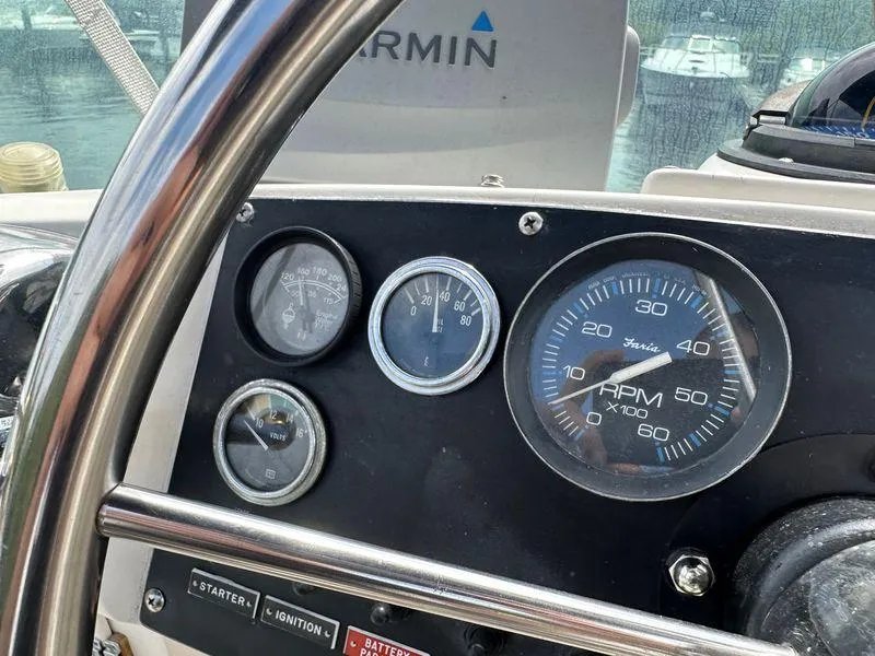 Slide: The Image of 1983 Bertram 28 boat dashboard with gauges and Garmin navigation system. - 23