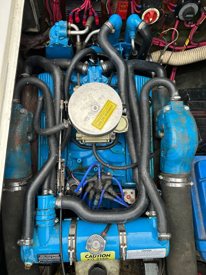 Slide: The Image of 1983 Bertram 28 boat engine with blue components and black hoses. - 30