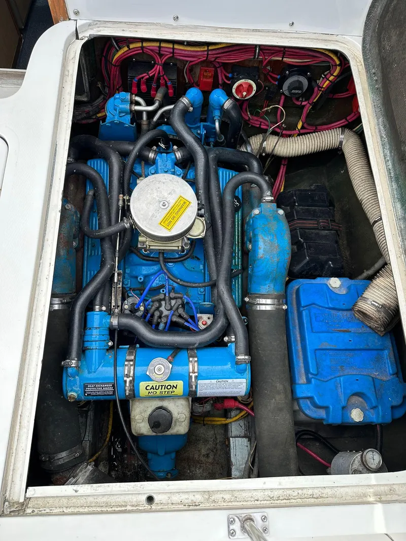 Slide: The Image of 1983 Bertram 28 boat engine compartment with blue engine and wiring. - 31
