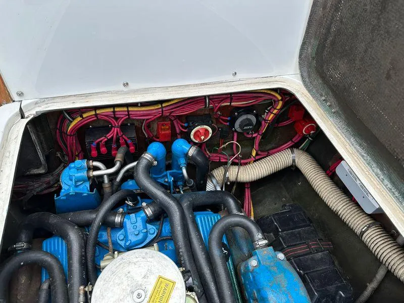 Slide: The Image of 1983 Bertram 28 engine compartment with blue engine and wiring. - 32