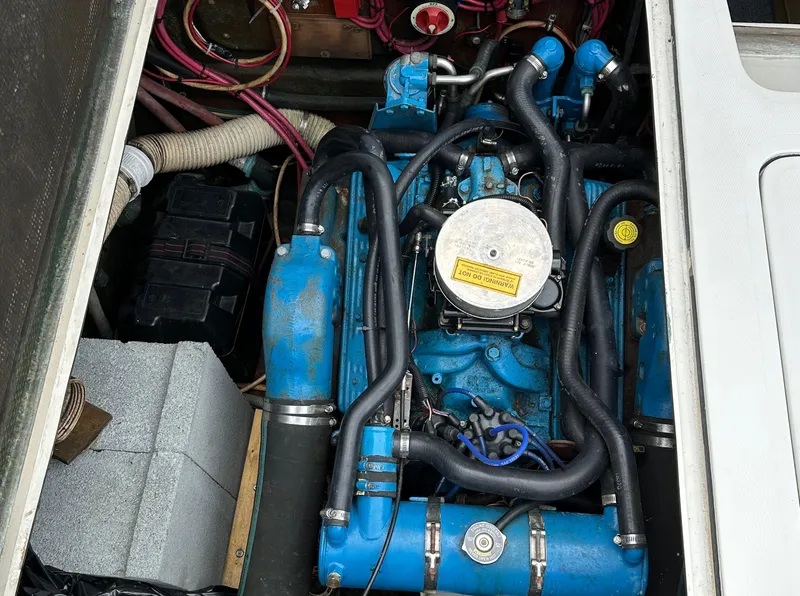 Slide: The Image of 1983 Bertram 28 boat engine compartment with blue engine and wiring. - 36