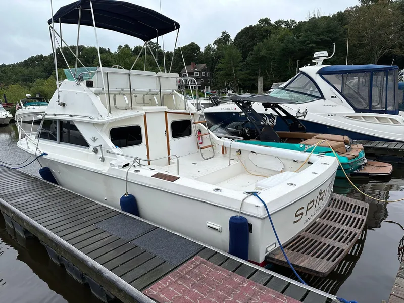 Slide: The Image of 1983 Bertram 28 boat docked at a marina with other boats. - 8