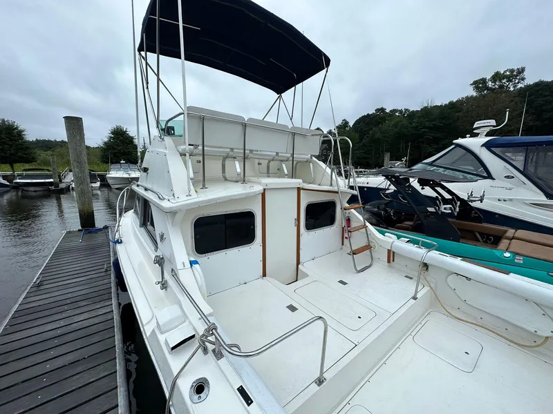Slide: The Image of 1983 Bertram 28 boat docked at marina, rear view. - 9