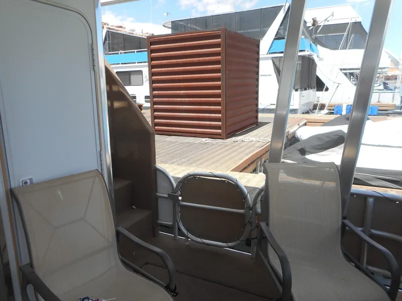 Slide: The Image of Two chairs on a boat deck, featuring a wooden structure, Sharpe Mysterious Waves 2004. - 12