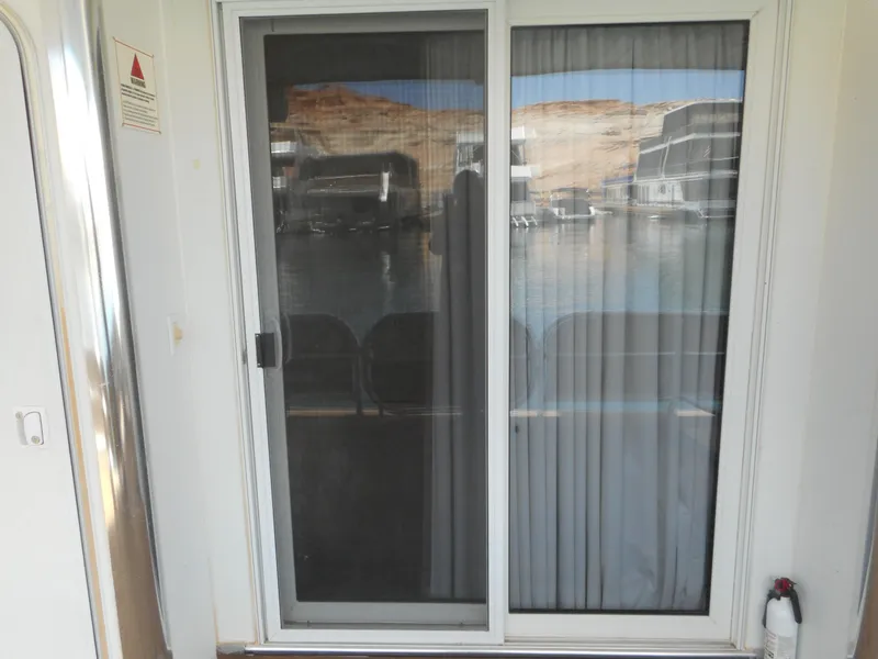 Slide: The Image of Sliding glass door with curtain, reflecting a scenic waterfront view. Sharpe Mysterious Waves, 2004. - 14