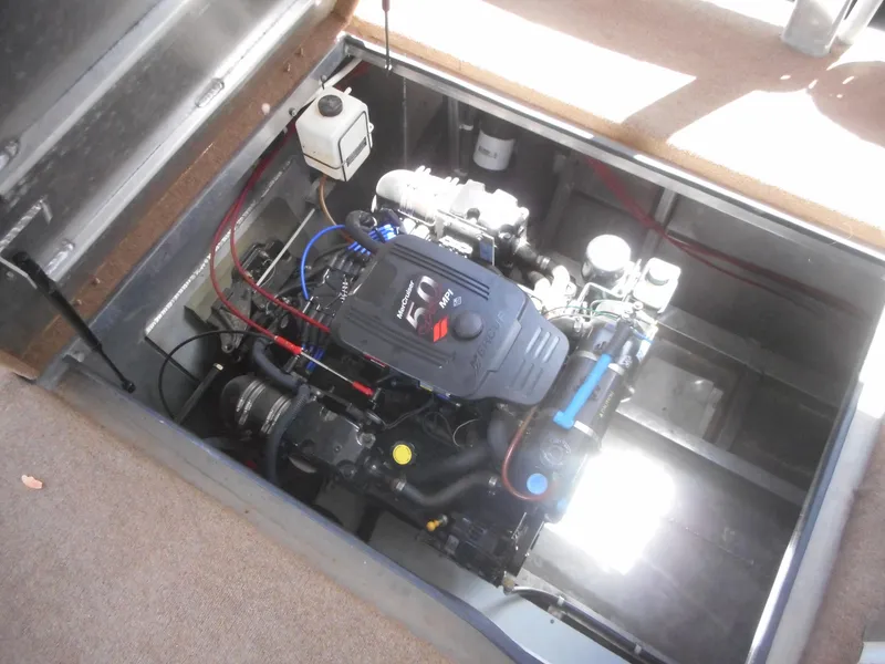 Slide: The Image of Engine compartment of a 2004 Sharpe Mysterious Waves boat, showcasing detailed mechanical components. - 16