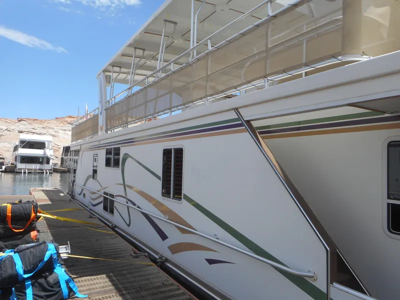 Slide: The Image of Houseboat docked at marina, Sharpe Mysterious Waves 2004 model, featuring colorful side design. - 2