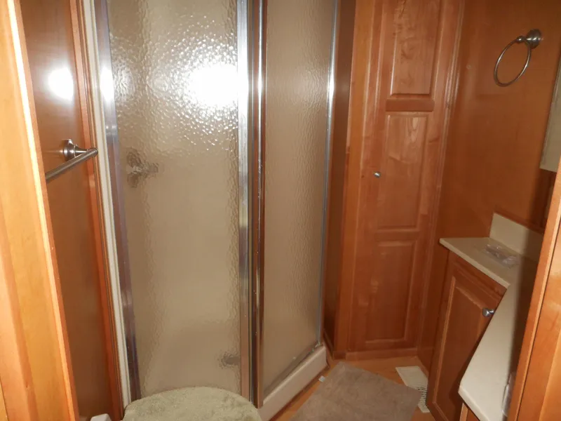 Slide: The Image of Compact wooden bathroom with shower, vanity, and storage in 2004 Sharpe Mysterious Waves model. - 23