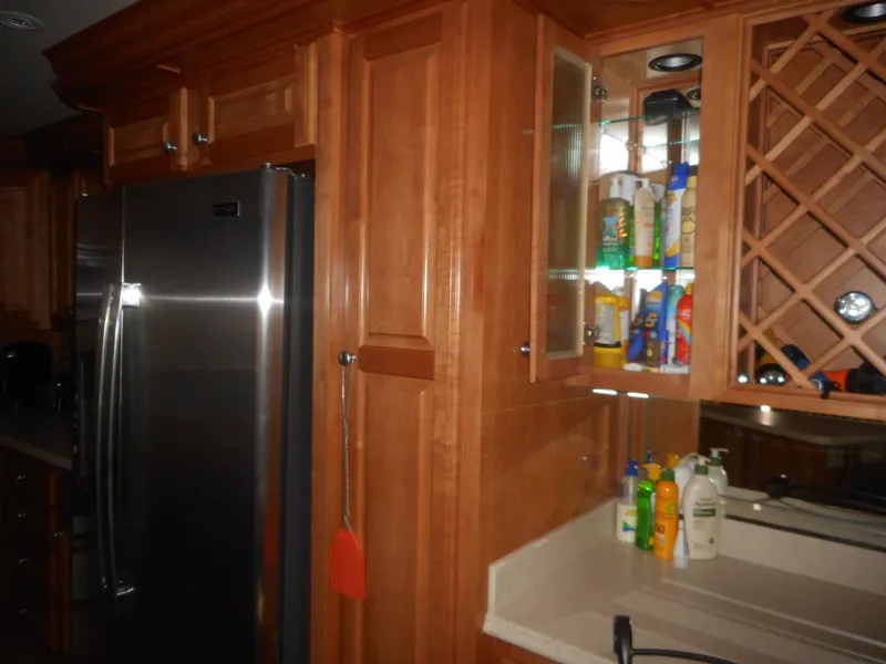 Slide: The Image of Luxurious kitchen with wooden cabinets, stainless steel fridge, and countertop cleaning supplies. - 27