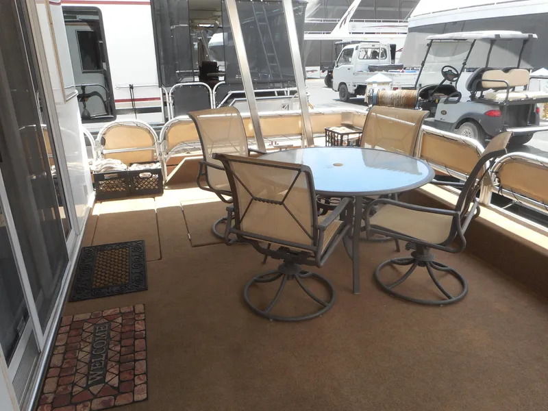 Slide: The Image of Outdoor seating area on a 2004 Sharpe Mysterious Waves houseboat, featuring a glass table and chairs. - 3