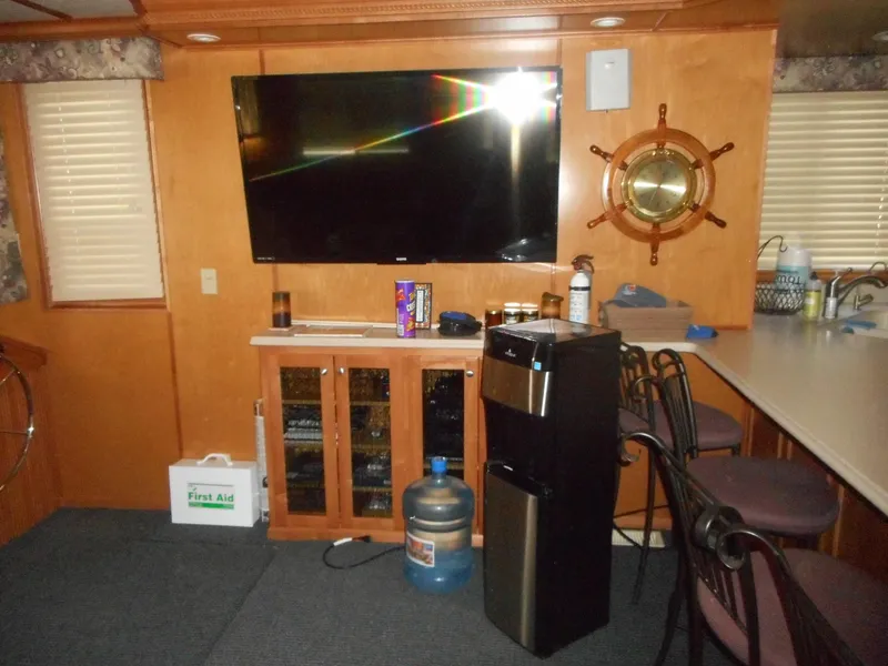 Slide: The Image of Interior of a 2004 Sharpe Mysterious Waves boat with TV, water cooler, and nautical decor. - 32