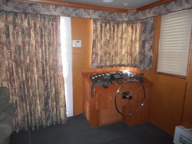 Slide: The Image of Control room of 2004 Sharpe Mysterious Waves boat with floral curtains and steering wheel. - 34