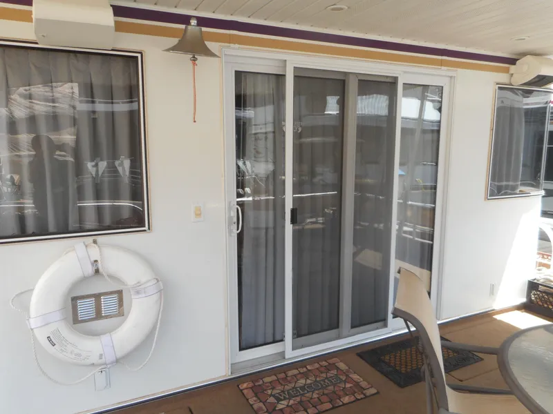 Slide: The Image of Sliding glass door on a 2004 Sharpe Mysterious Waves houseboat with life preserver and patio chair. - 4
