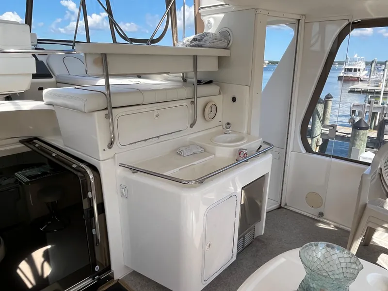 Slide: The Image of 1997 Sea Ray 420 Aft Cabin yacht interior with kitchenette and seating area. - 10