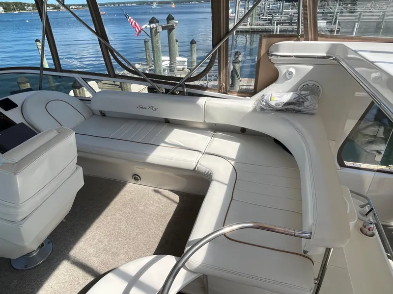 Slide: The Image of 1997 Sea Ray 420 Aft Cabin boat interior with white seating and waterfront view. - 14