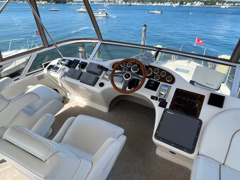 Slide: The Image of 1997 Sea Ray 420 Aft Cabin helm with leather seats and wooden steering wheel. - 15