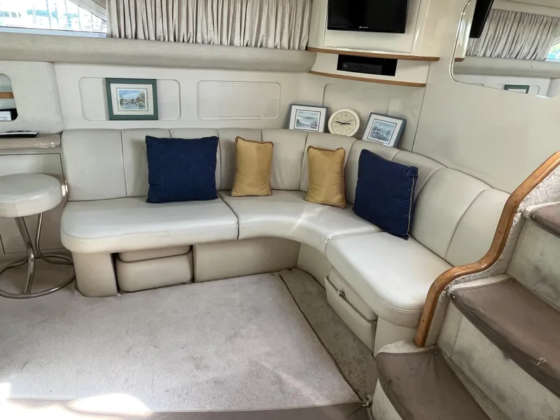 Slide: The Image of 1997 Sea Ray 420 Aft Cabin interior with white leather seating and decorative pillows. - 23