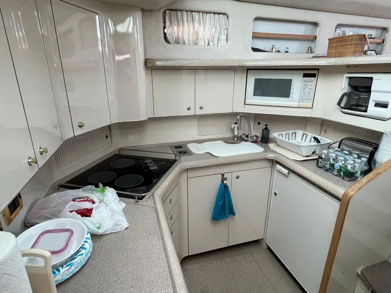 Slide: The Image of 1997 Sea Ray 420 Aft Cabin kitchen with microwave, stove, and sink. - 30