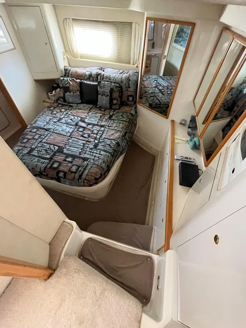 Slide: The Image of 1997 Sea Ray 420 Aft Cabin bedroom with bed, mirrors, and storage. - 34