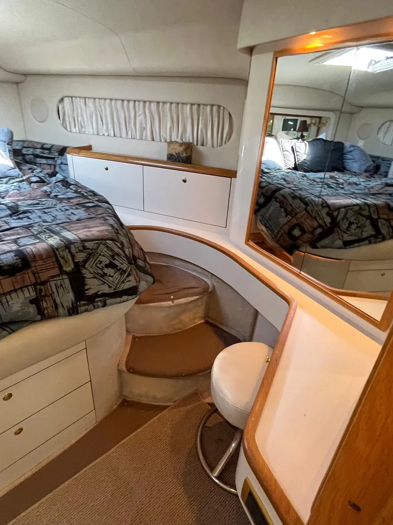 Slide: The Image of 1997 Sea Ray 420 Aft Cabin bedroom with bed, vanity, and storage. - 36