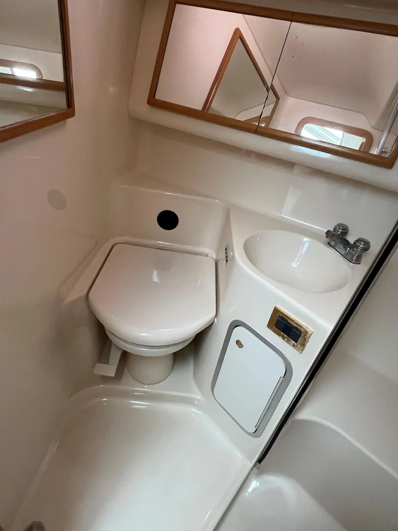 Slide: The Image of 1997 Sea Ray 420 Aft Cabin bathroom with toilet, sink, and mirror. - 39