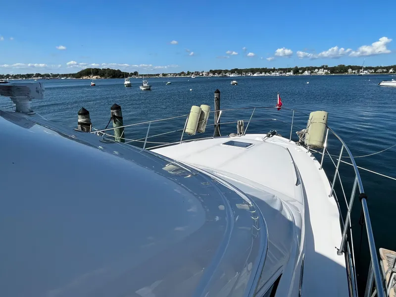 Slide: The Image of 1997 Sea Ray 420 Aft Cabin yacht docked in a scenic harbor. - 4